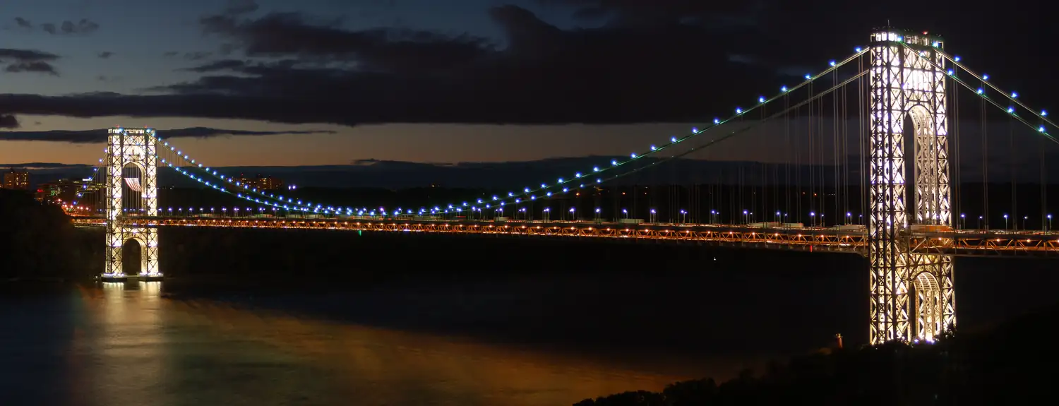 A suspension bridge lit at night.